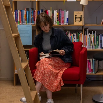 Lena blättert in einem Buch in der Bibliothek des Schweizerischen Literaturinstituts. Foto: HKB / Tina Schück