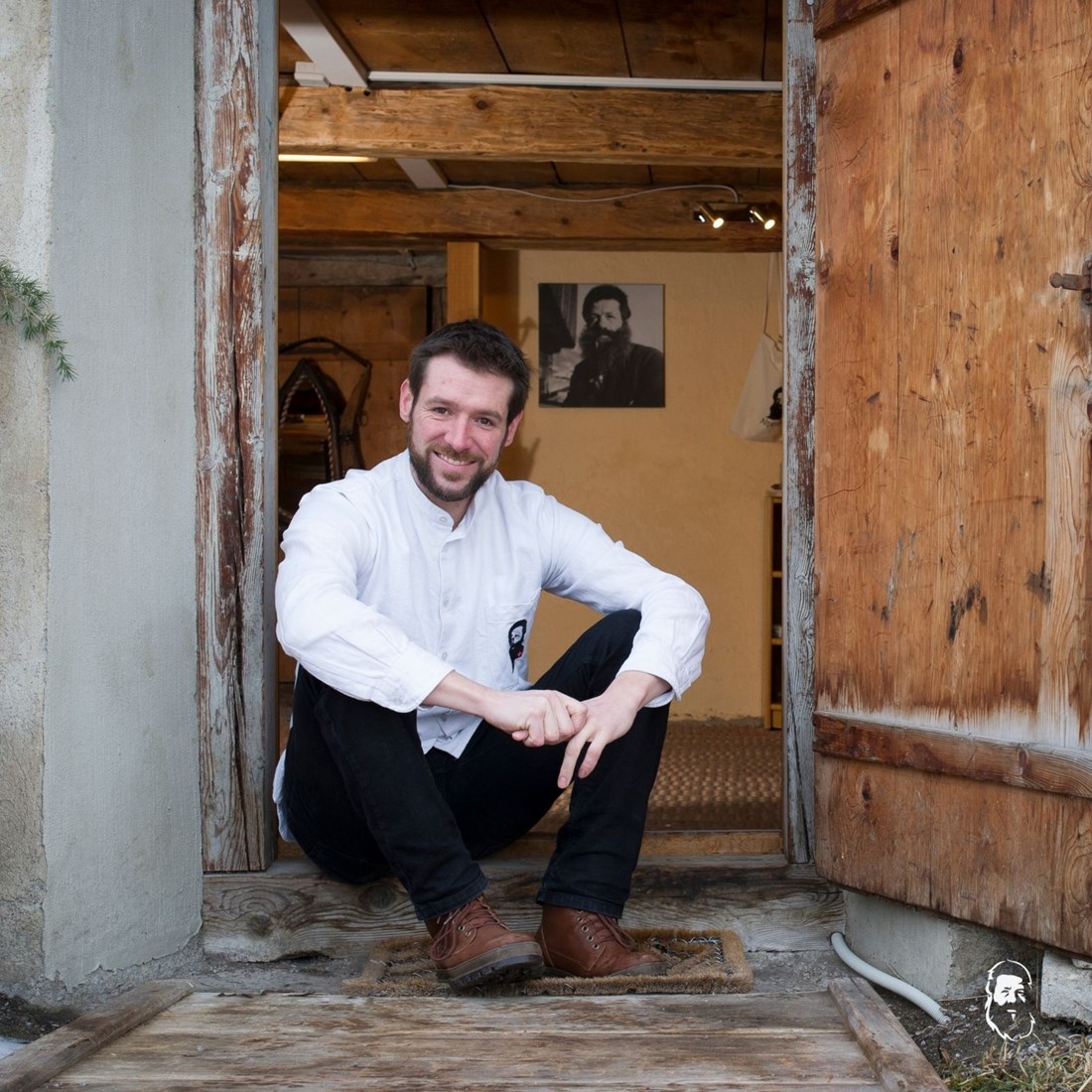Adrian Hirt vor seinem Alpenkeller, im Hintergrund das Bild seines Urneni, der als Vorlage für das Logo diente. (Bild: Simon Kneuenbühl) Adrian Hirt vor seinem Alpenkeller, im Hintergrund das Bild seines Urneni, der als Vorlage für das Logo diente. (Bild: Simon Kneuenbühl)
