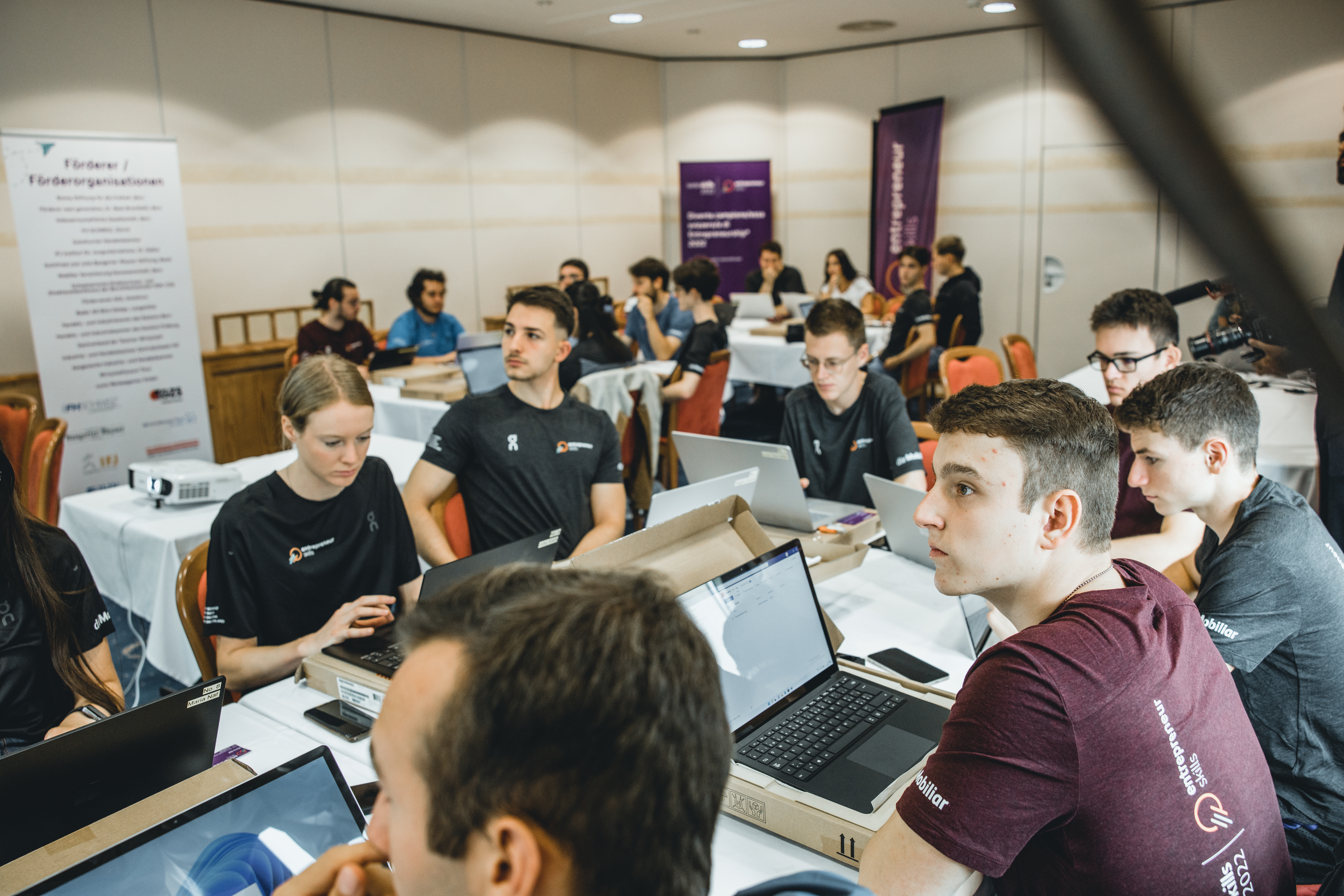 Die Finalistinnen und Finalisten hören konzentriert den Inputs zu