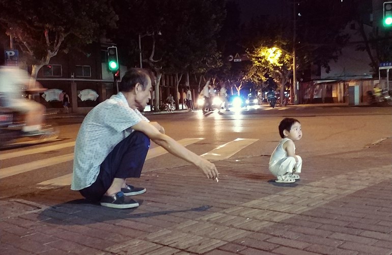 Die durchaus gesunde Körperhaltung der tiefen Hocke ist in China allgegenwärtig, ob bei jung oder alt.