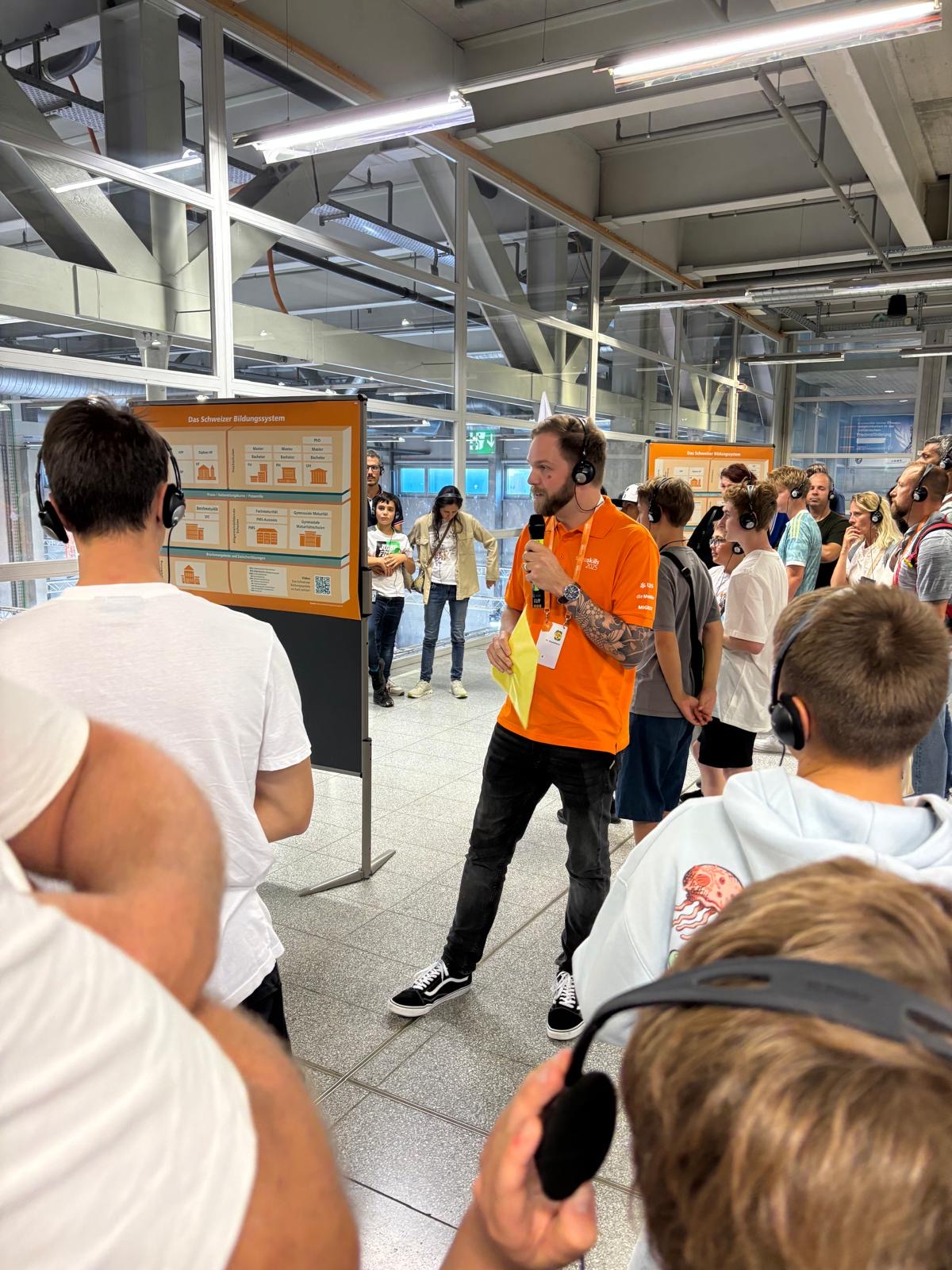 Sven Schmid erklärt seiner Gruppe (Familien) das Schweizer Bildungssystem