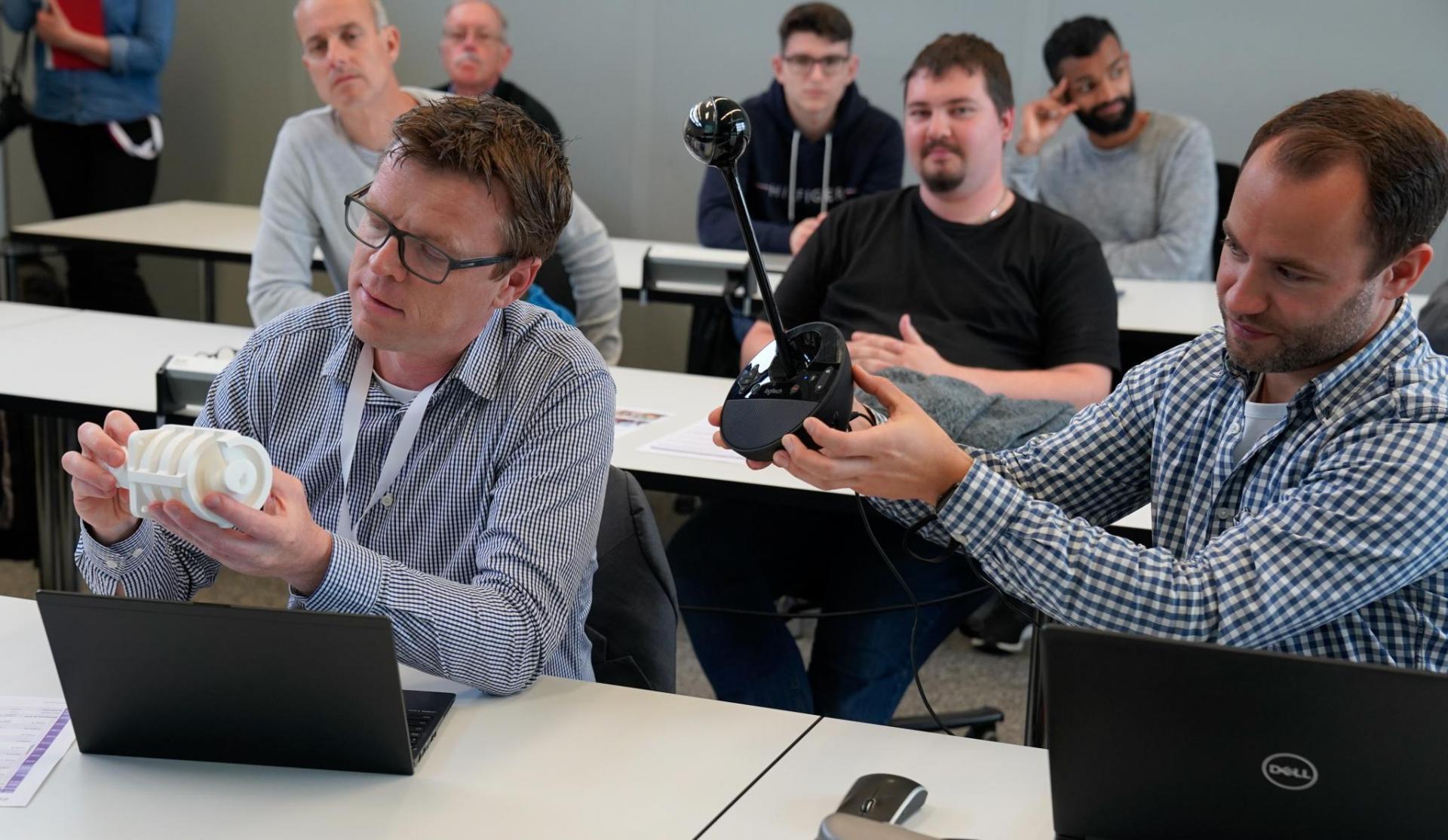 Marcel Soltermann betrachtet Details von Prototypen, Volvo ist über Video dabei